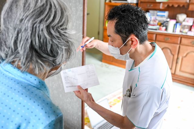 薬剤師がご自宅を訪問し、患者さまにお薬の説明をしている様子